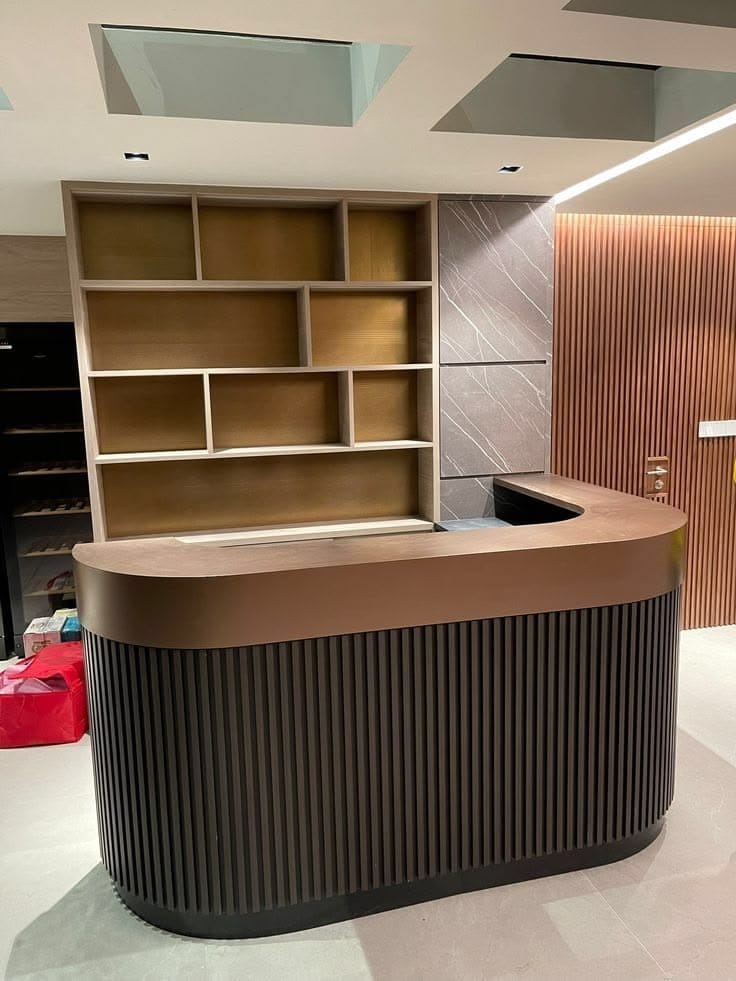 Copper-topped reception desk with wood display shelving