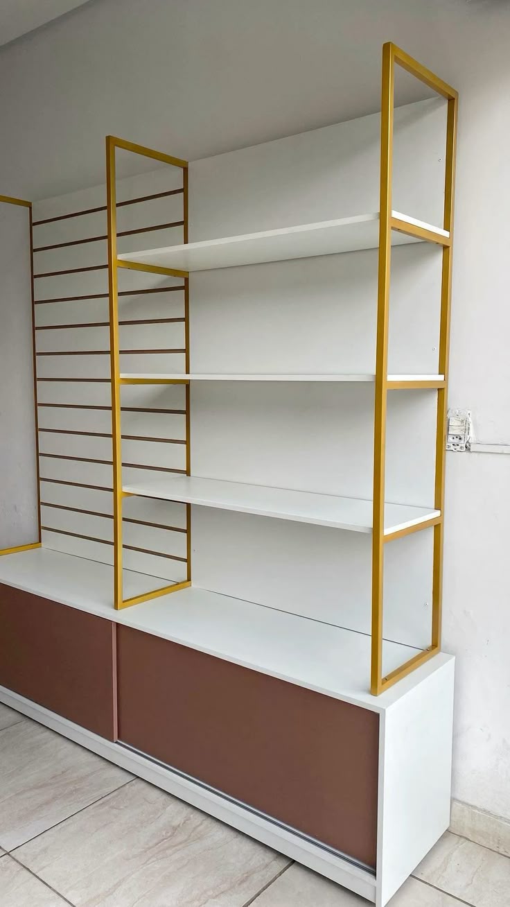 Gold ladder shelving unit above brown sliding cabinet doors